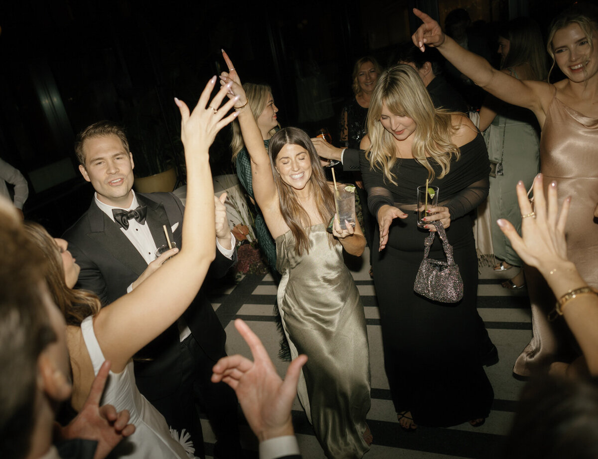 wedding guests cheer and dance at a Shinola Hotel wedding reception in Detroit