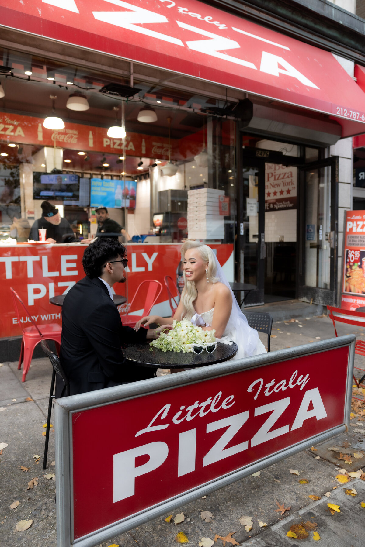 Candid shot of the couple laughing while eating pizza at their NYC elopement celebration.