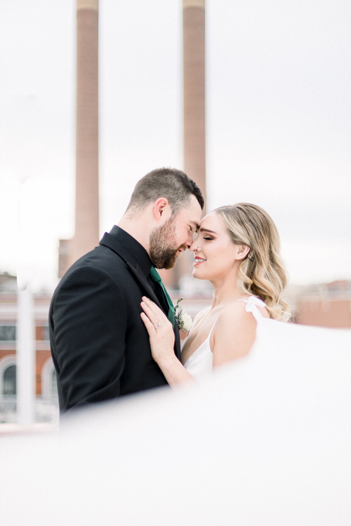 Bride and groom smiling at each other in love on an rooftop in Spokane WA- taken by spokane wedding photographer