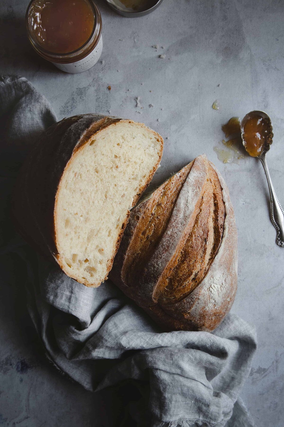 Dark and moody food photography of artisan sourdough bread and jam, styled for bakeries and food brands in Washington DC.