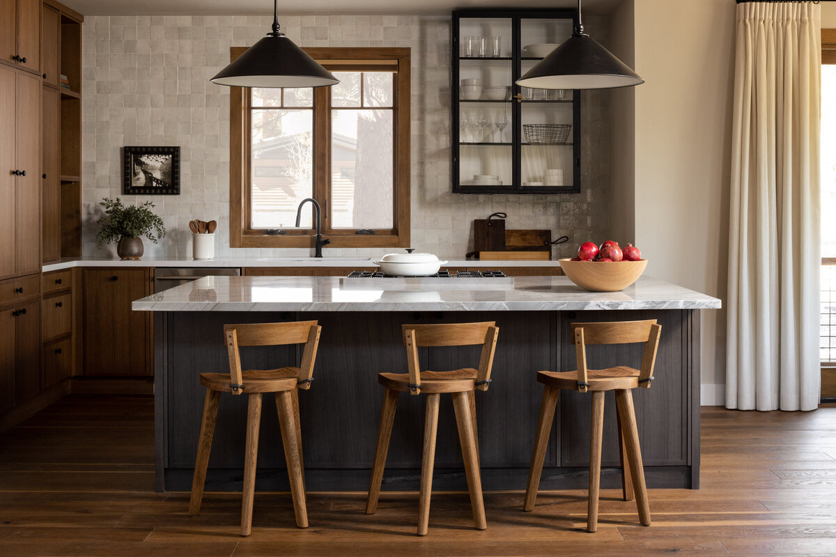 Contemporary kitchen with marble countertops and wooden bar stools, showcasing interior photography