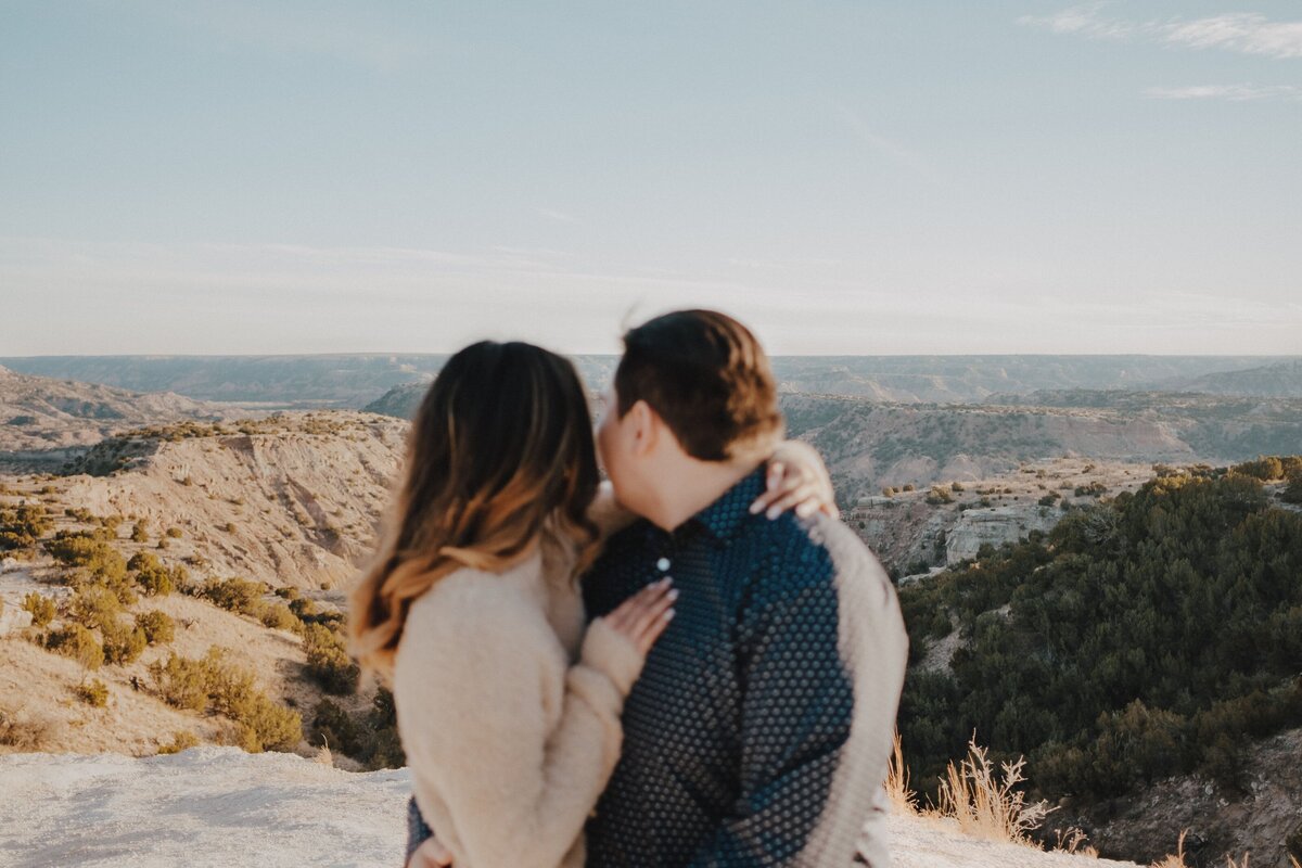 Engaged couple looking out into Palo Duro Canyon during their adventure engagement session