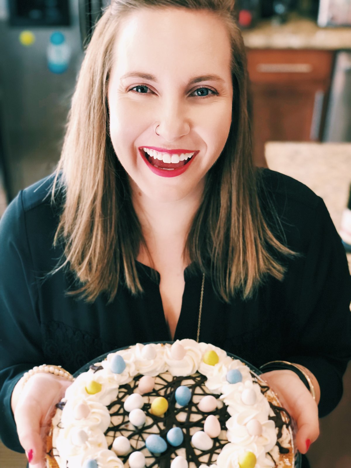 A girl holding a cake and smiling at the camera