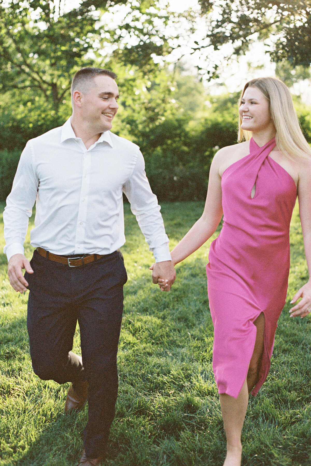 Engaged couple walking hand-in-hand surrounded by lush Columbus garden shot by Philadelphia photographer.