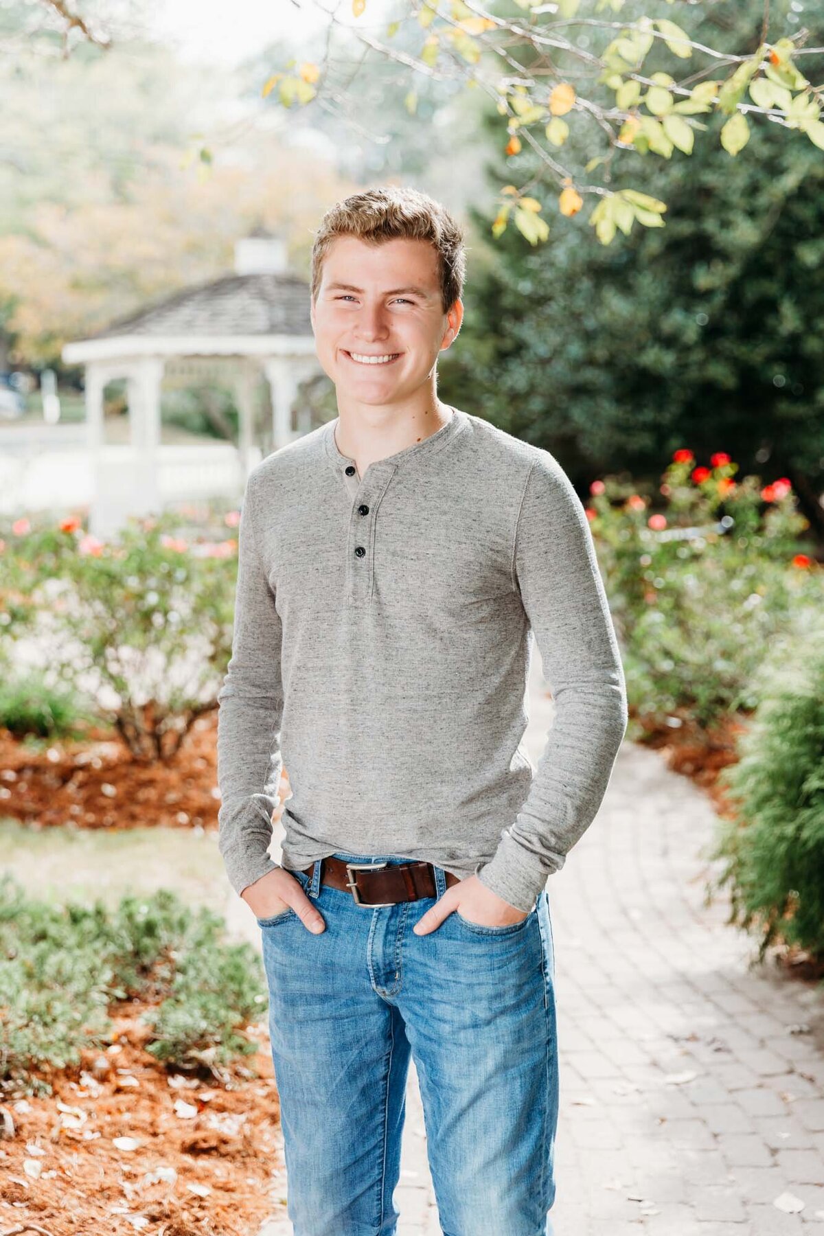 Senior portrait of a handsome guy in a garden.