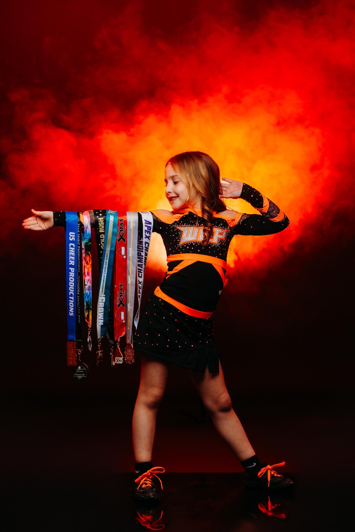 Youth competitive cheerleader showing off winning medals.