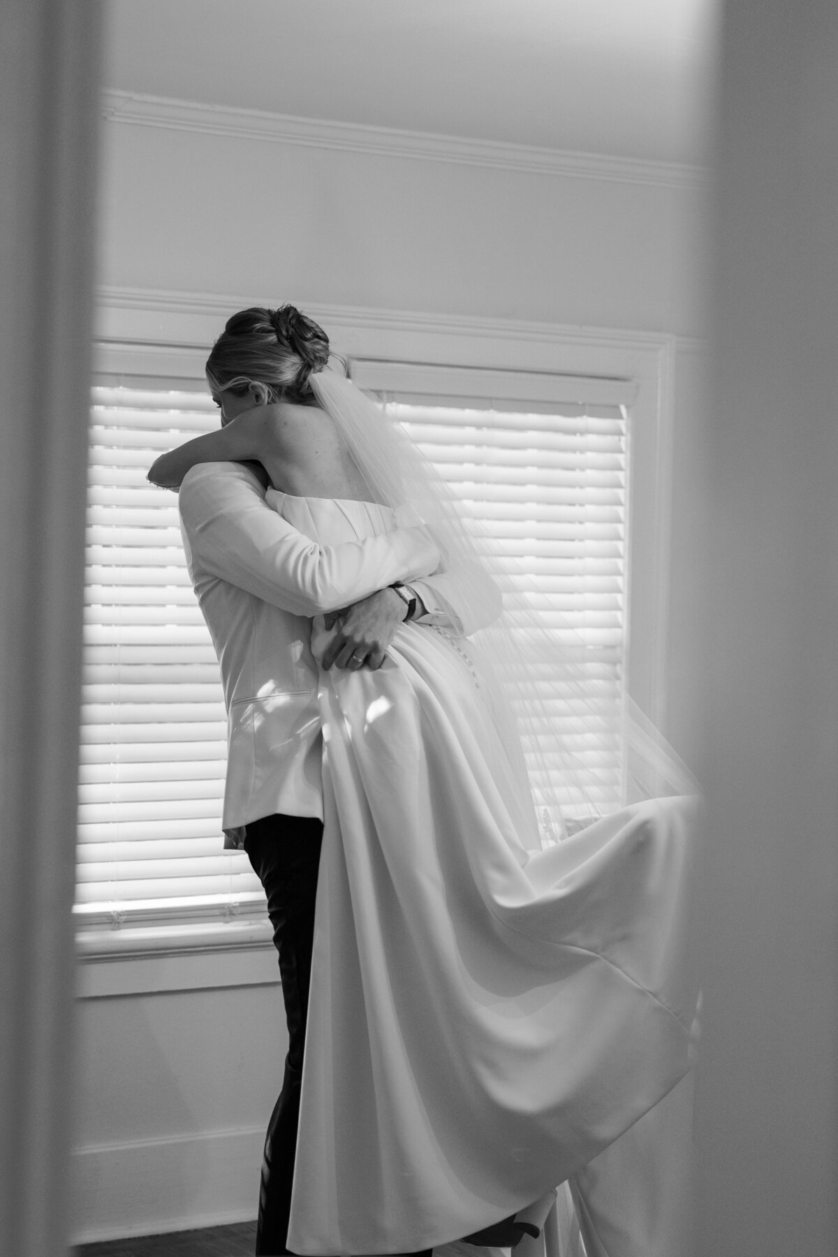 Bride and groom hug after wedding ceremony in the bridal suite at Wingate place