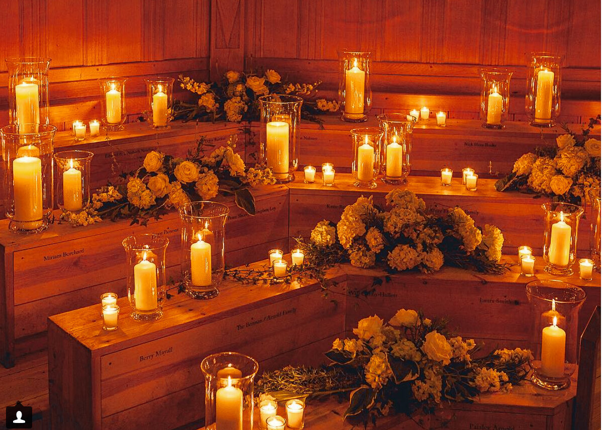 A wooden theatre is set with candles and flowers for a wedding ceremony.