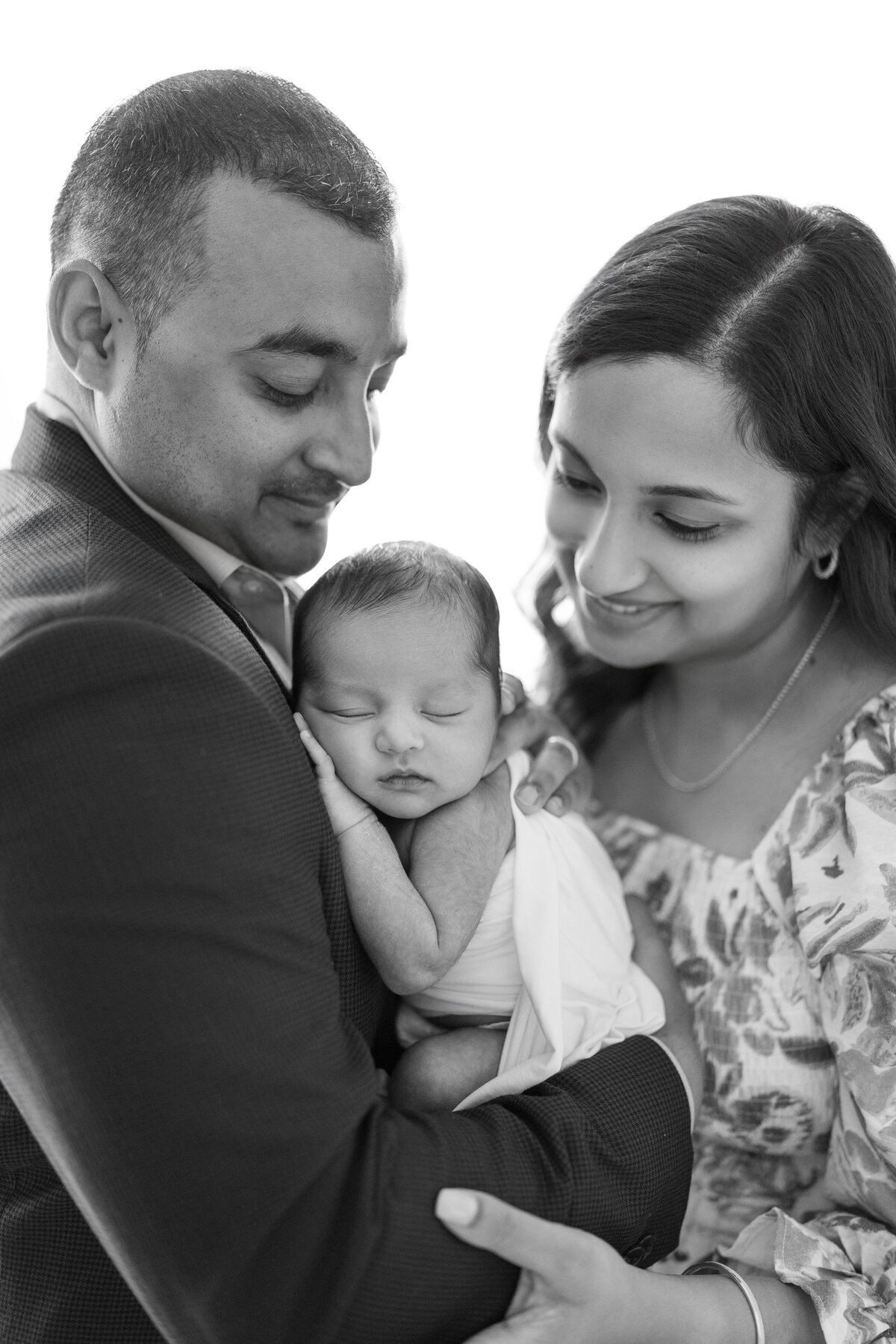 Emotive black and white family portrait with newborn boy in Tampa natural light photography studio
