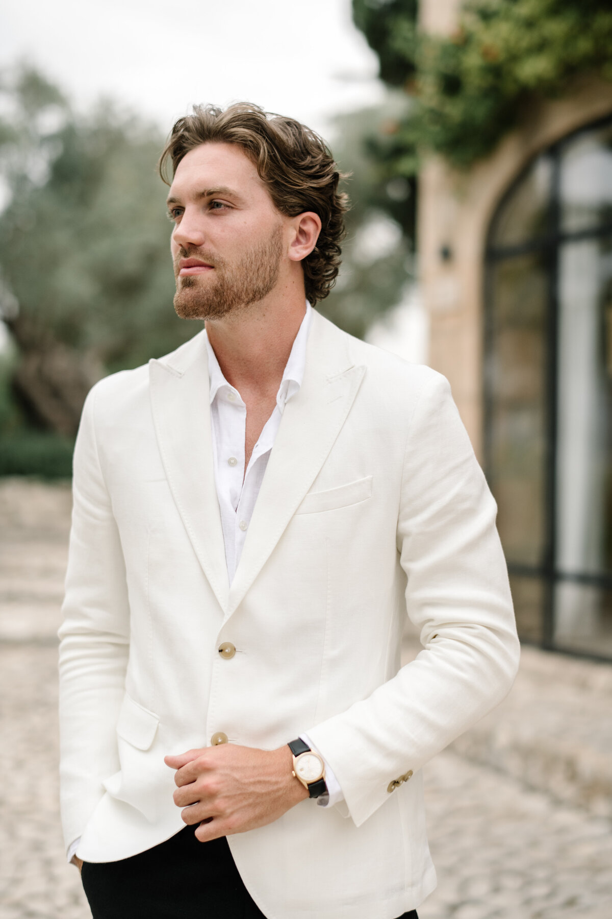 groom in ivory light colored suit jacket and black pants
