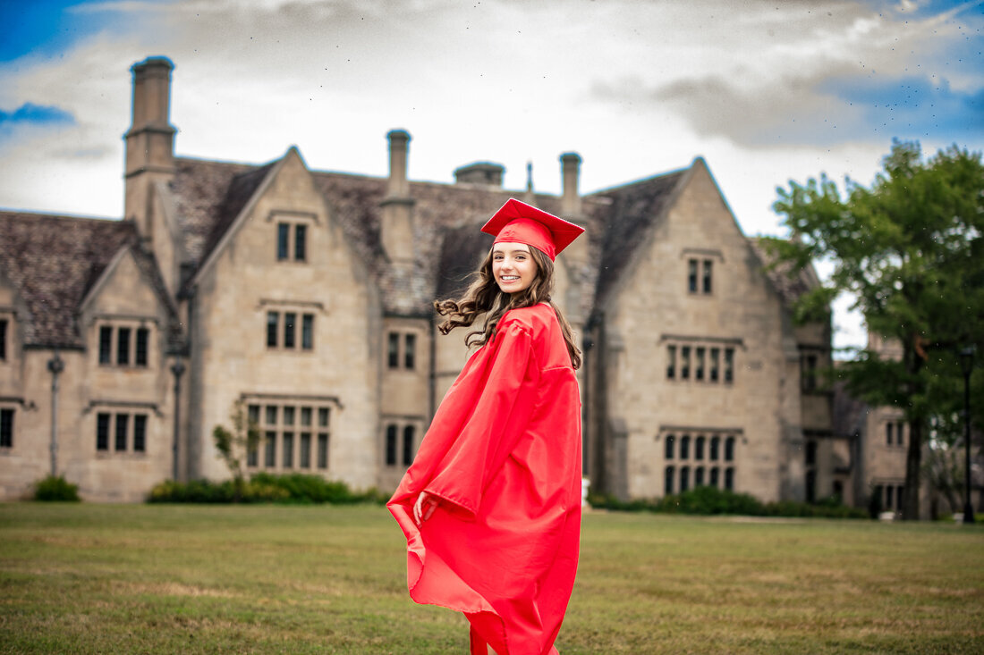 Celebratory graduation portrait in red cap and gown at historic Pittsburgh manor. 