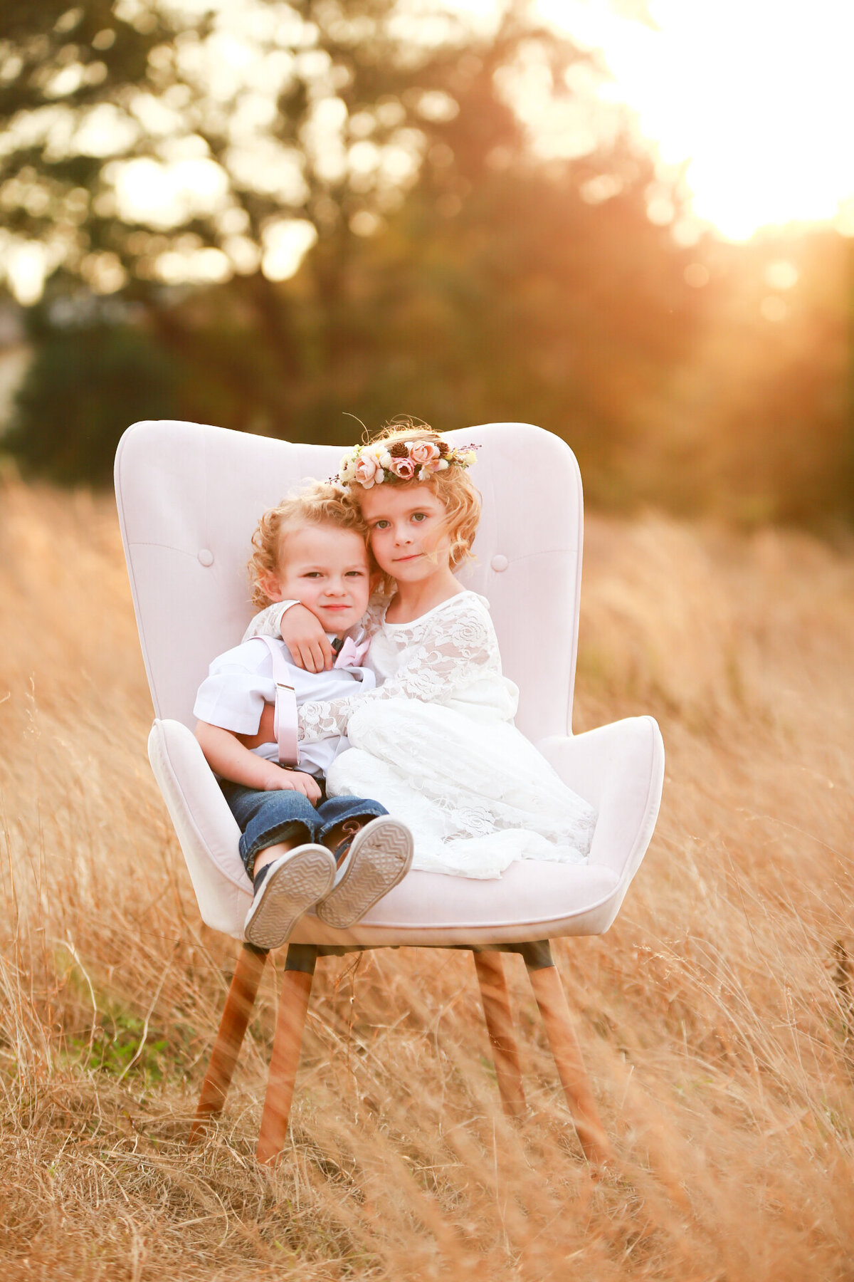 boho sibling photo shoot sitting in chair in field by Florida photographer
