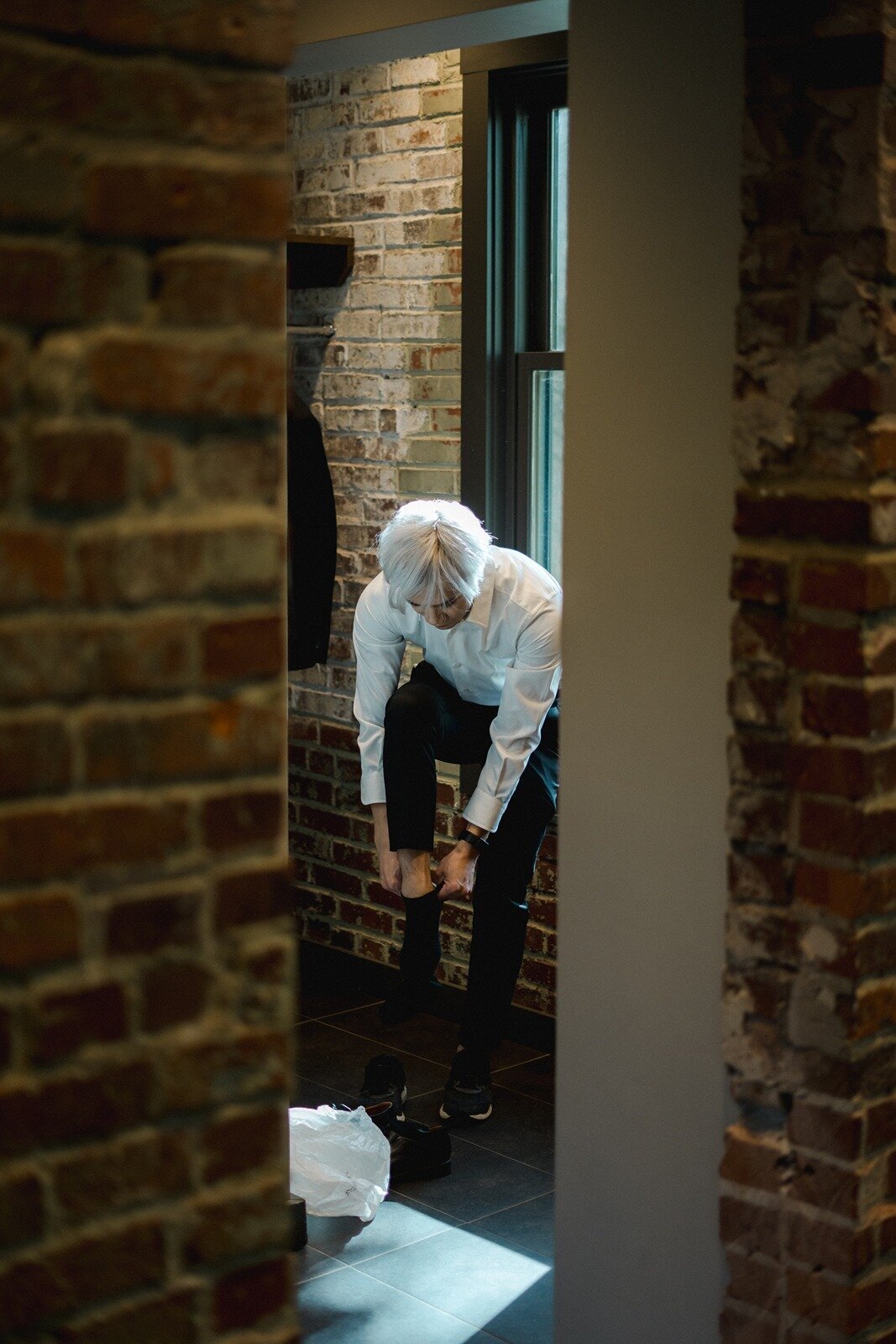 Groom fixing his socks to wear his shoes
