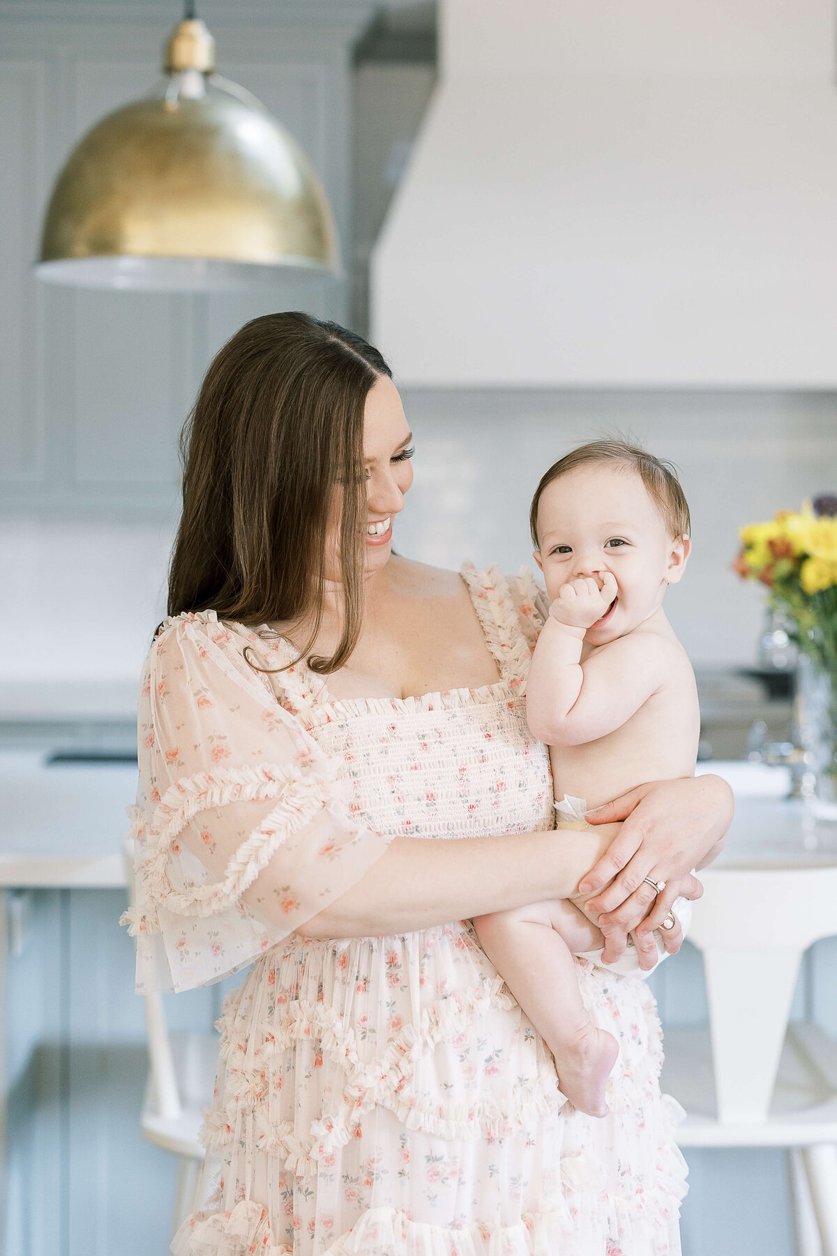 a mom holding her baby in the kitchen