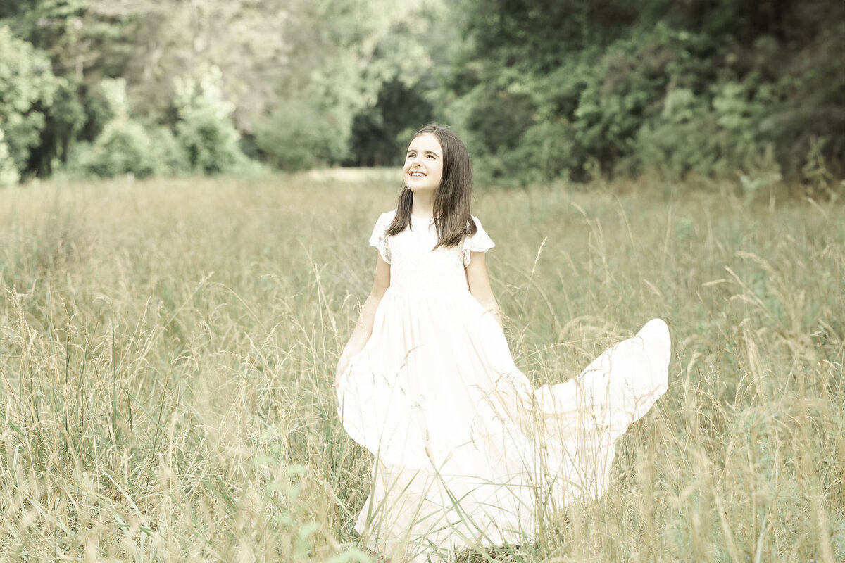 child in a beautiful flowing dress in a field in Hendersonville