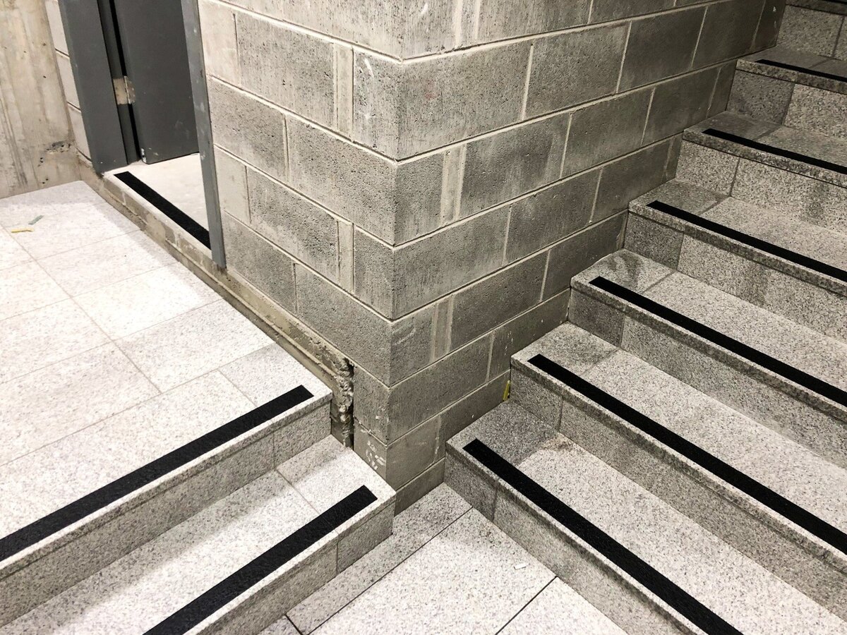 A set of stairs with newly finished stair nosing leading to a fire exit floor.