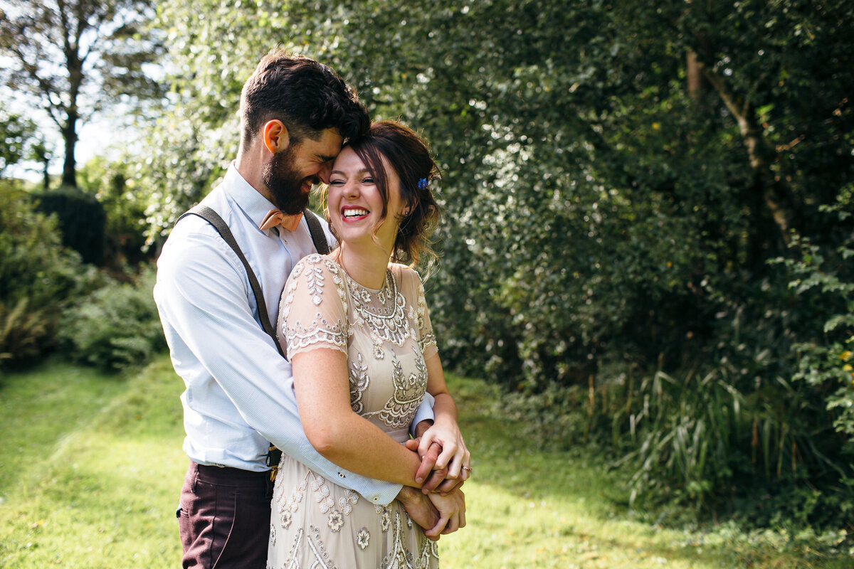 Couple embrace surrounded by greenery at their wedding in Devon 