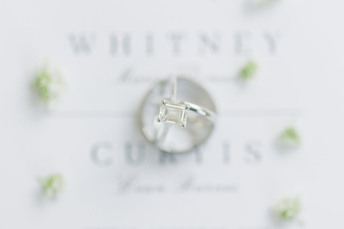 Wedding rings on white invitation suite representing Christine Hazel Photography's attention to detail