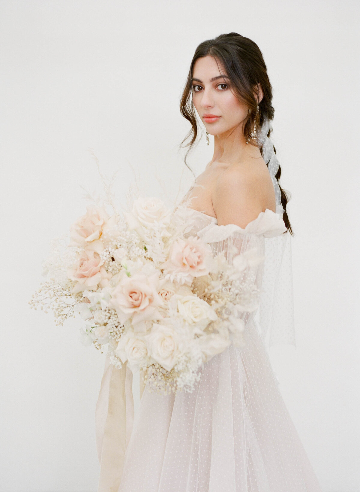 bride with fine art bouquet and braided hair style