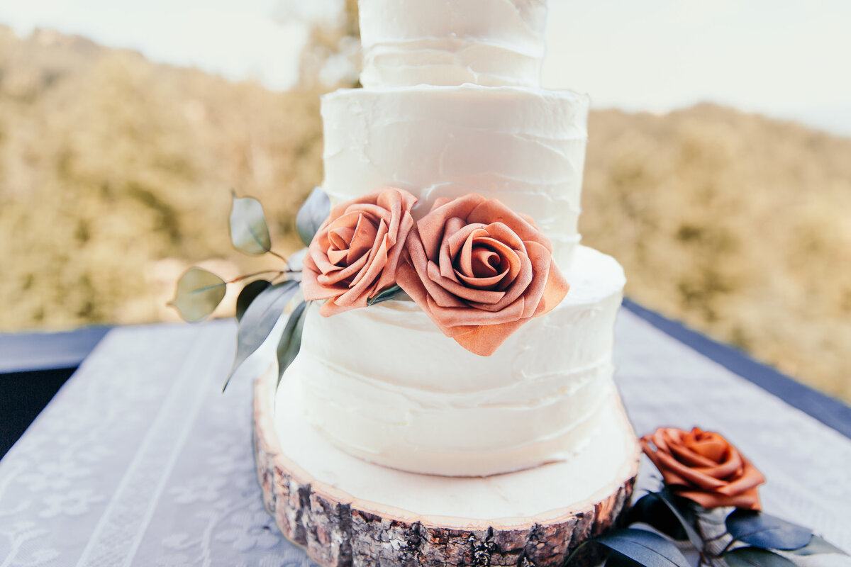 close up of roses on a white wedding cake