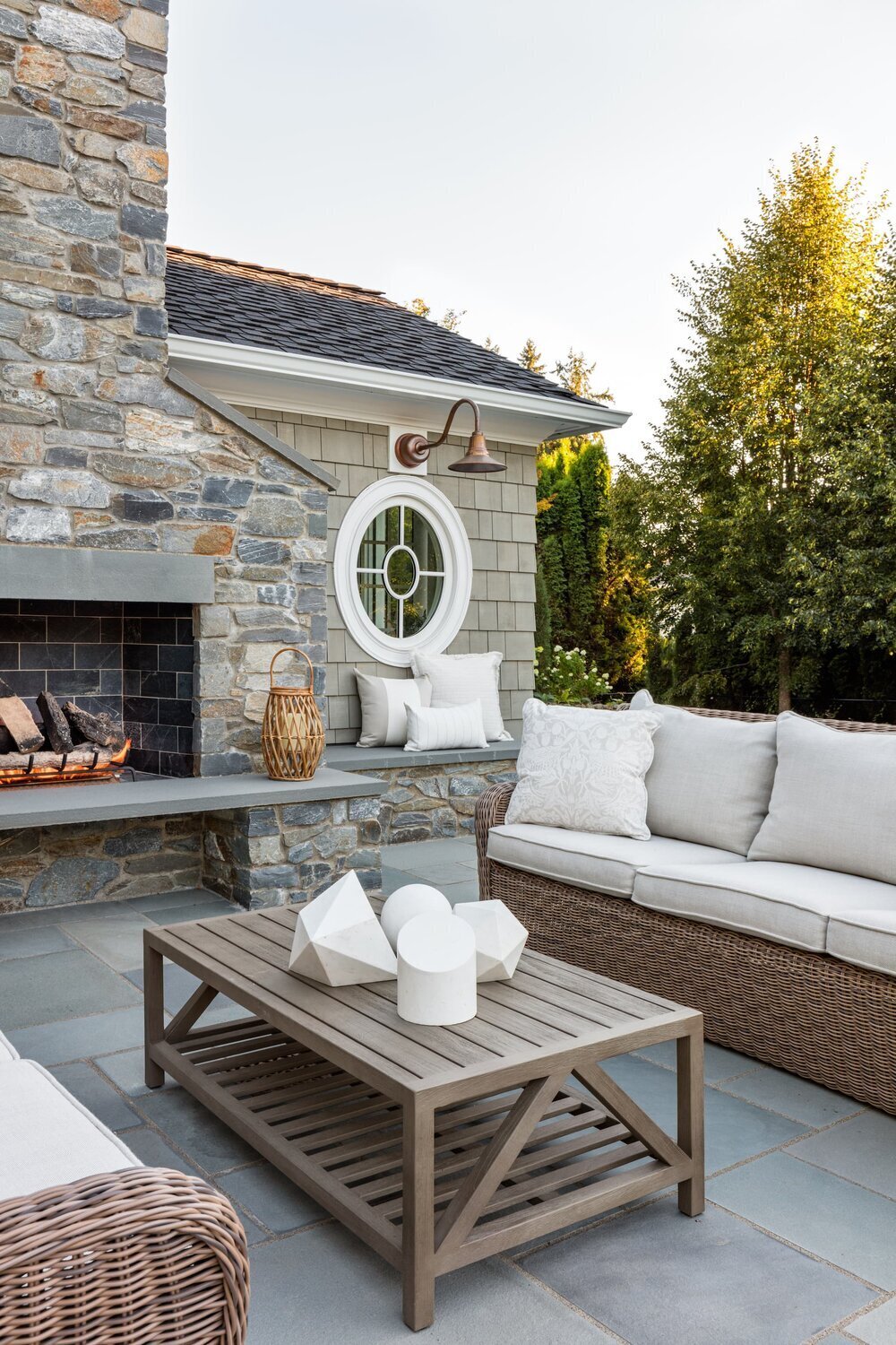 patio-stone-fireplace-cozy-seating-wicker-sofa