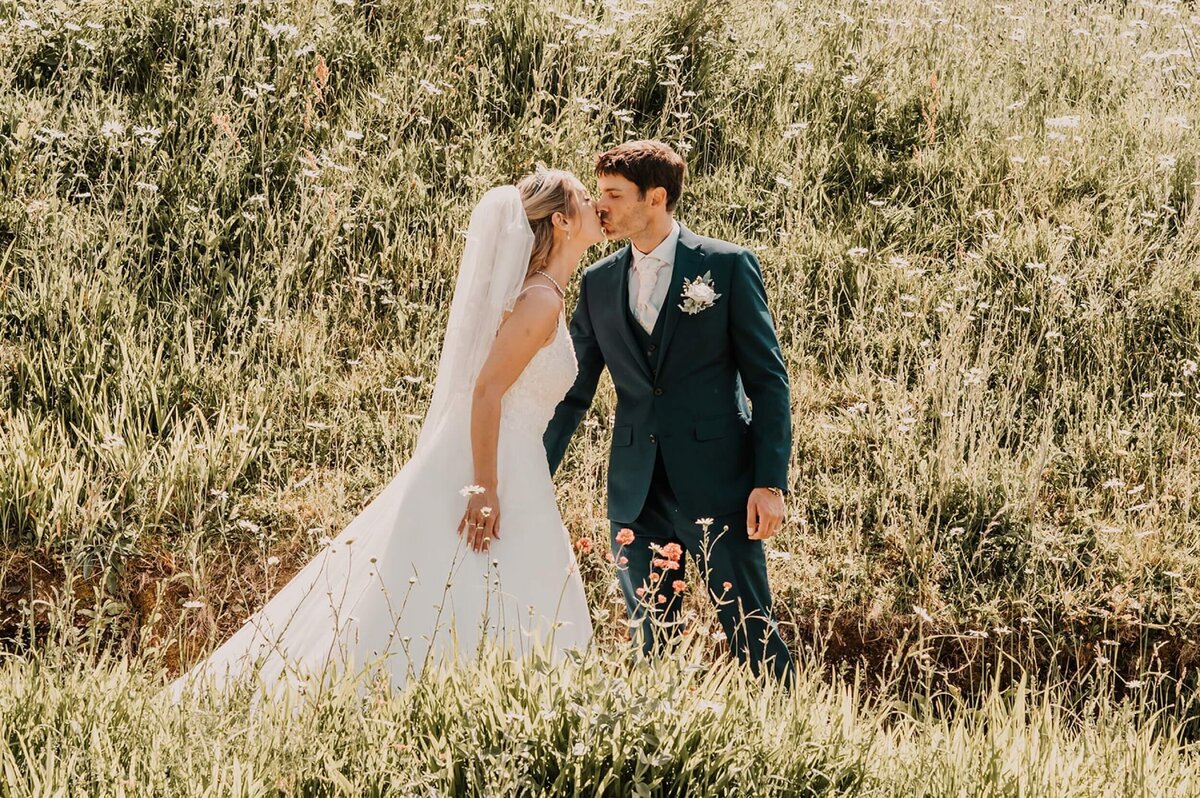 A bride and groom standing in a field