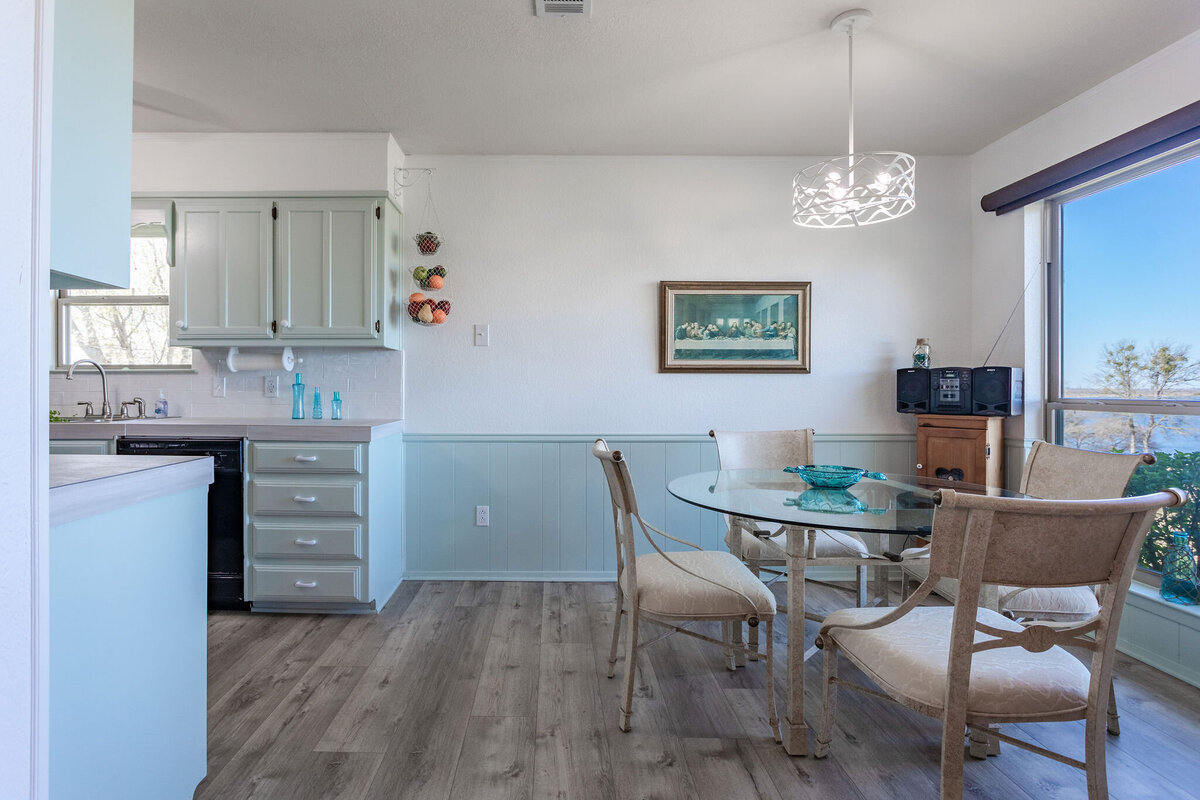 Spacious kitchen and dining room area with beautiful view of the lake in this 2-bedroom, 2-bathroom lakeside vacation rental home for 6 guests on Tradinghouse Lake with privacy access to a fishing dock and boat launch pad, ping pong table, gazebo, free wifi and free parking in Waco, TX.