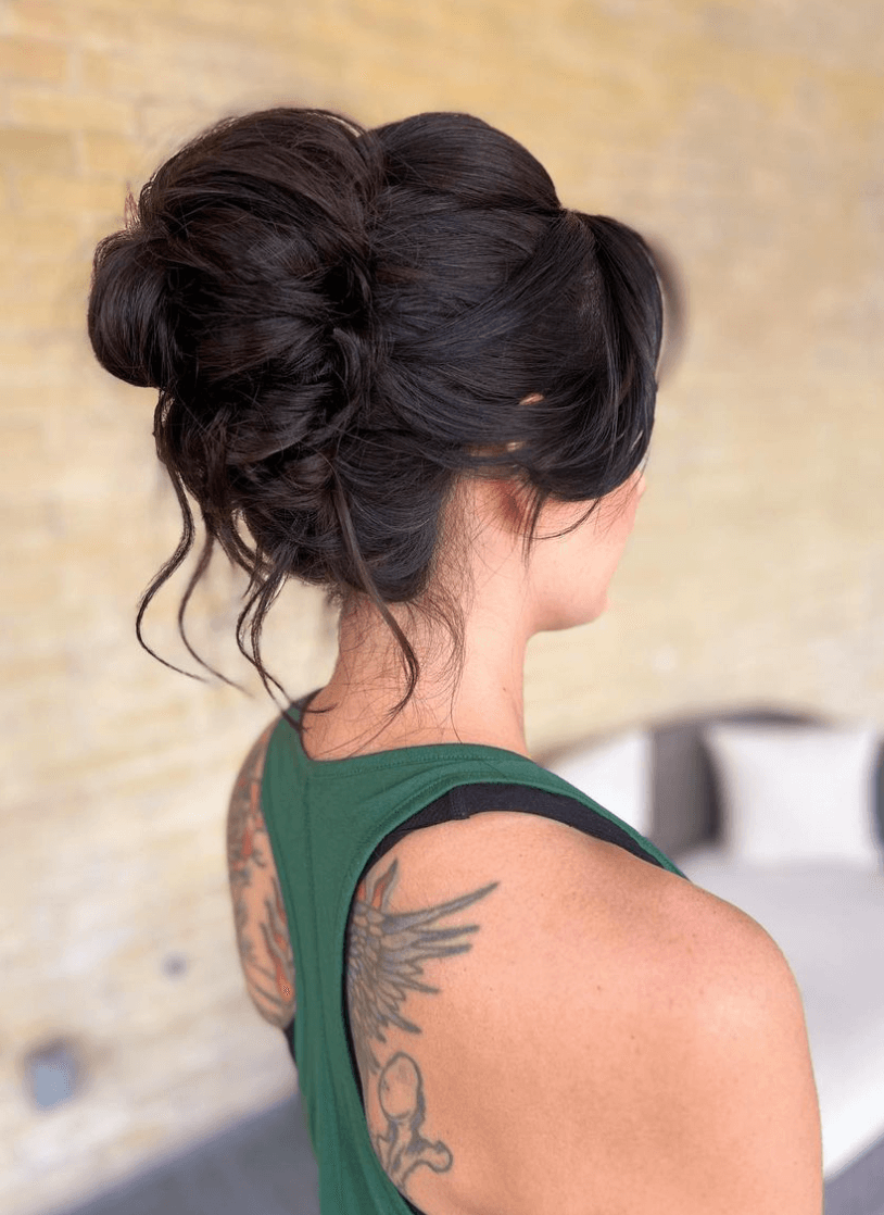 Messy updo with textured volume and loose front tendrils styled by a bridal hairdresser in San Antonio for wedding or formal event