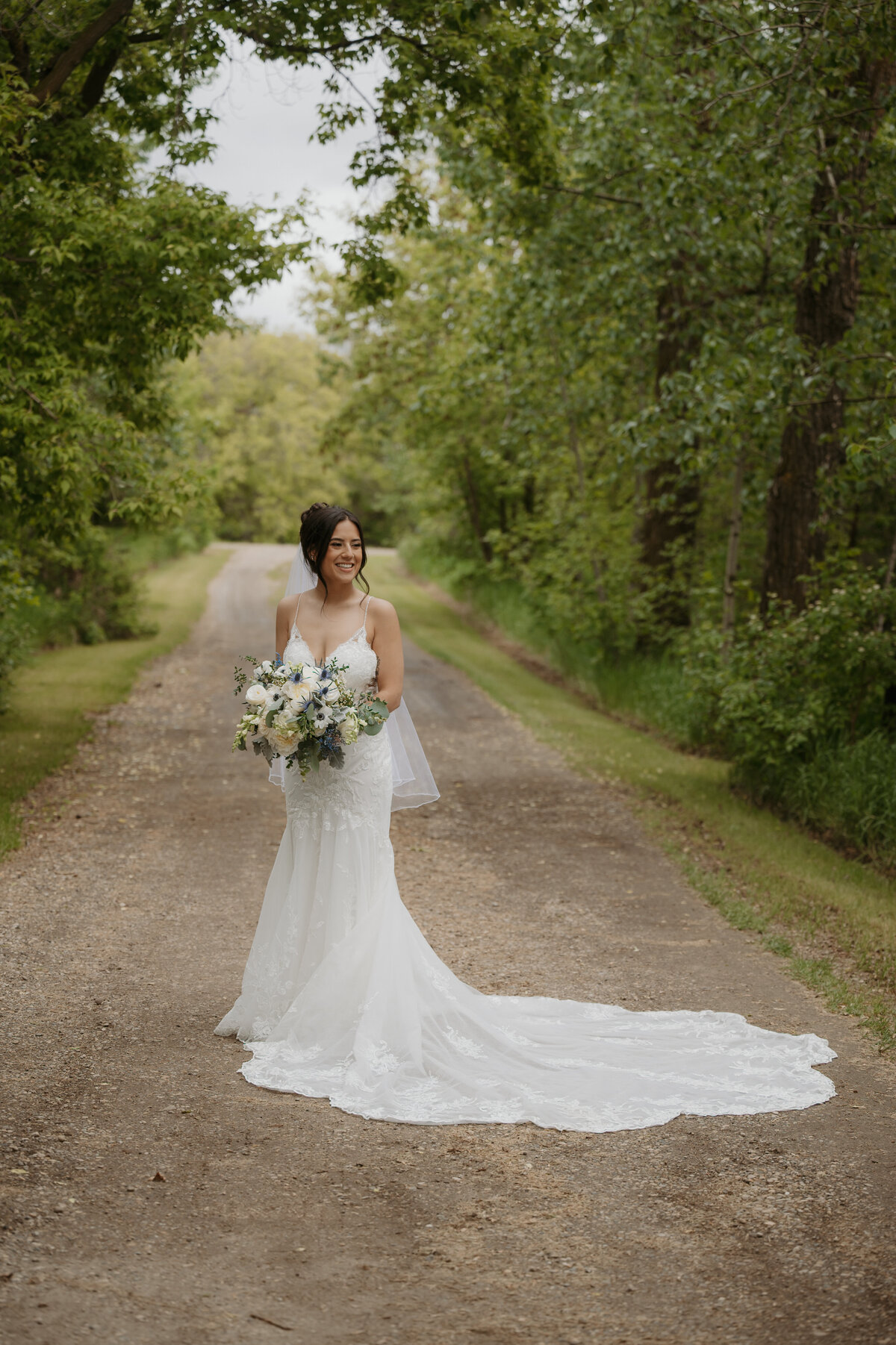 bride standing amongst trees at Gardenview wedding venue