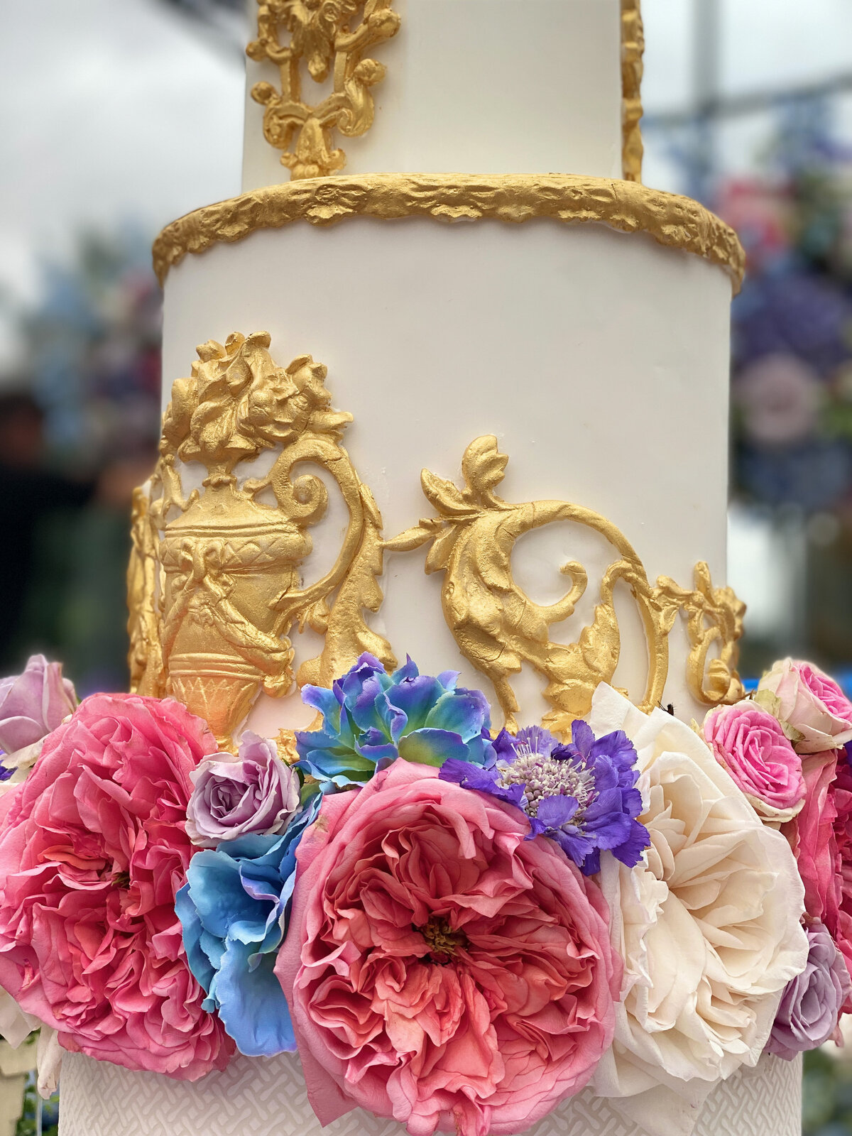 white and gold wedding cake with fresh flowers