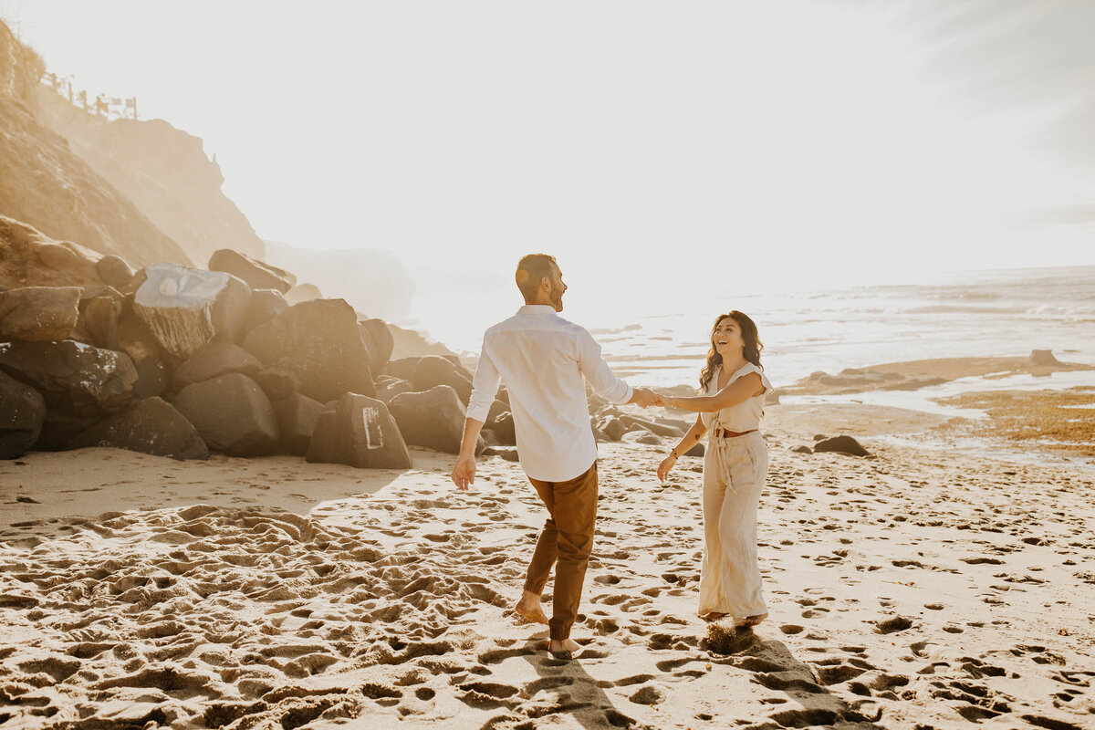 Couple in white dances at sunset on beach