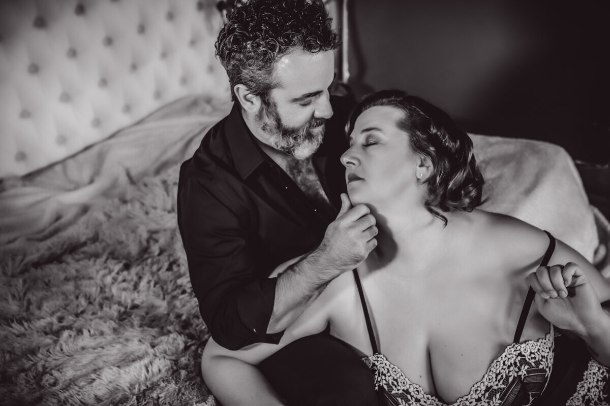 Beautiful boudoir image of woman sitting on mans lap in lingerie