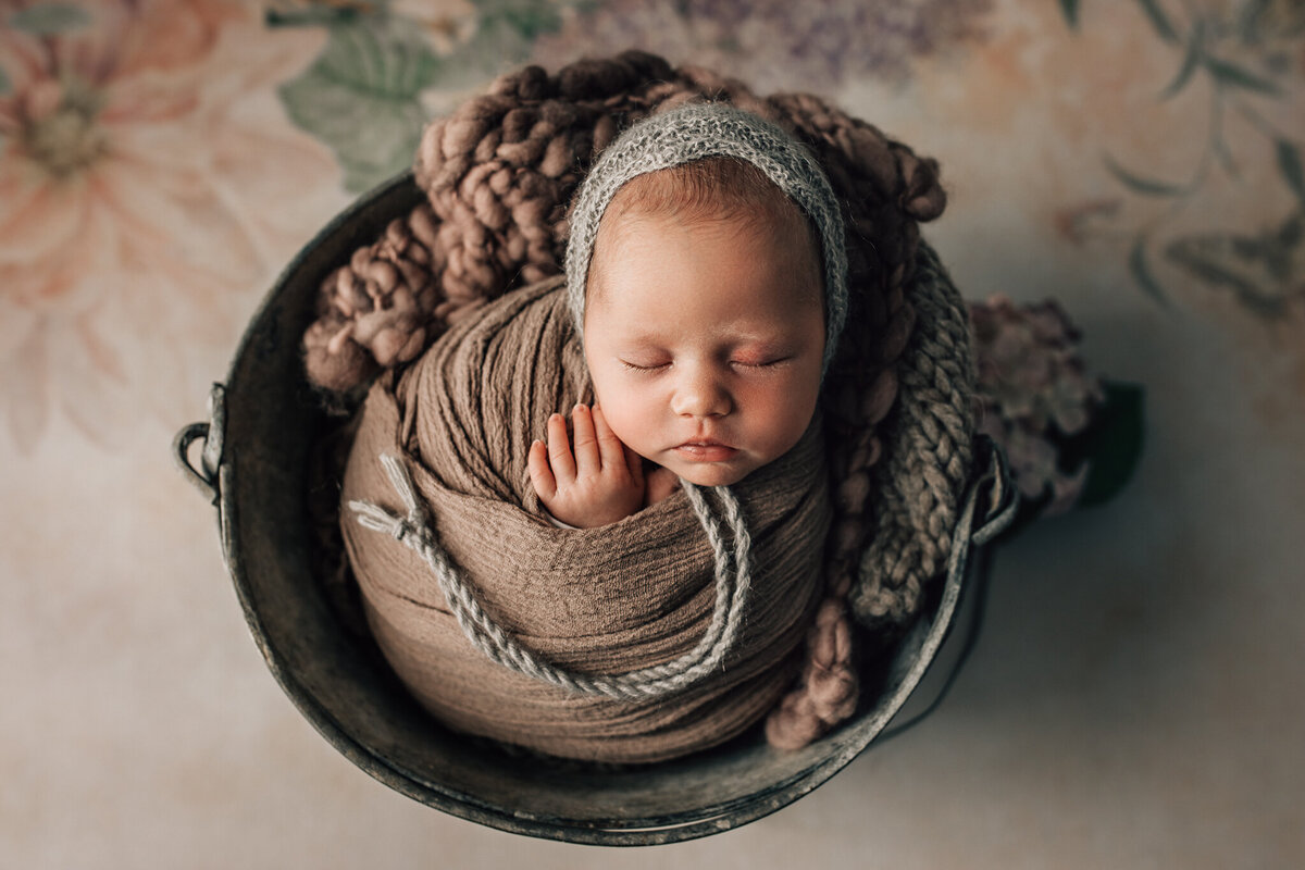 baby girl in bucket with delicate colours