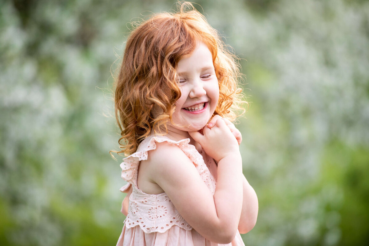 Ottawa family photography of a cute little girl with read hair smiling and laughing