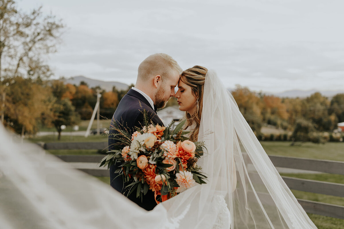Airy veil surrounding couple with terracotta florals.