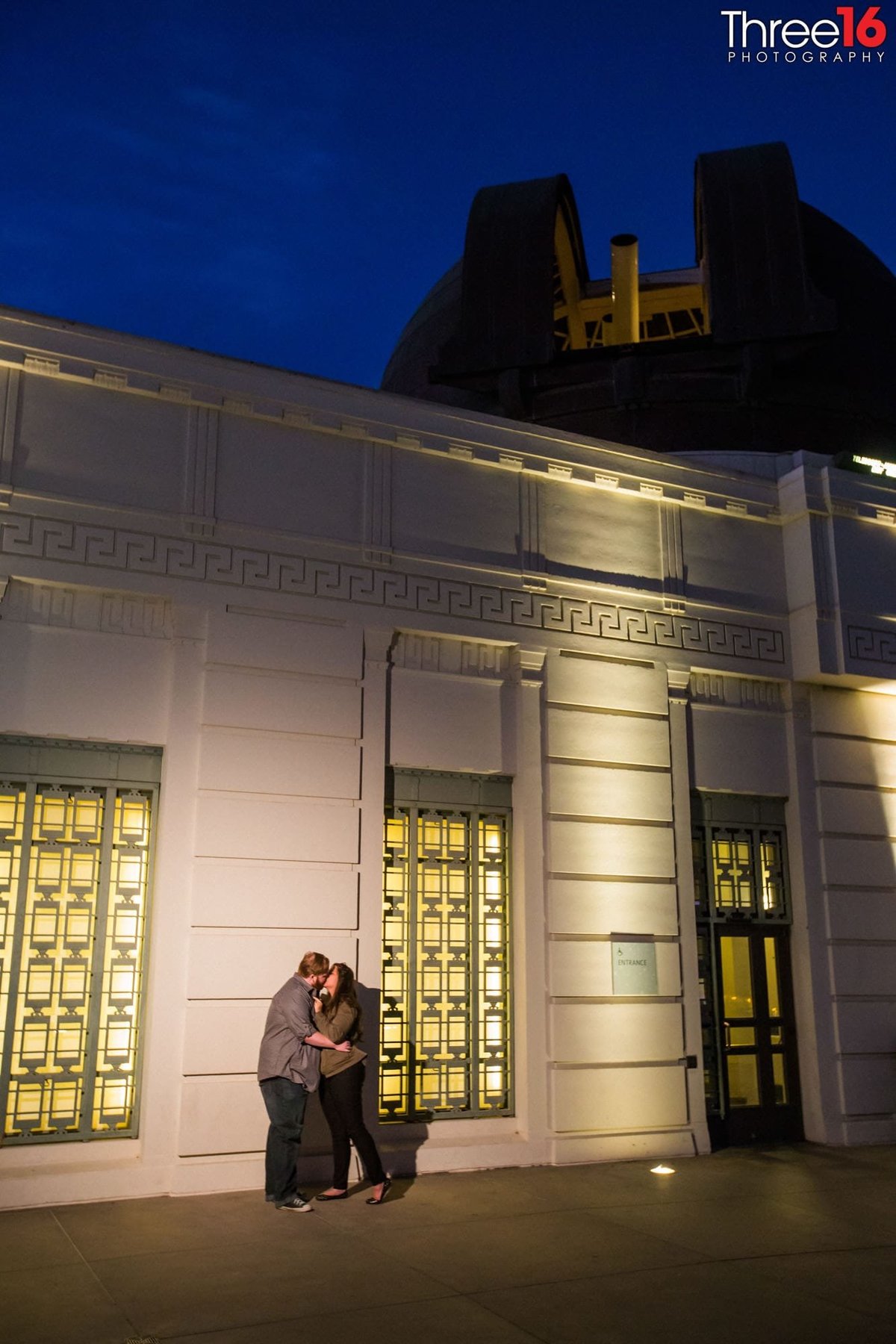 Engaged couple share a tender kiss outside of the Griffith Observatory