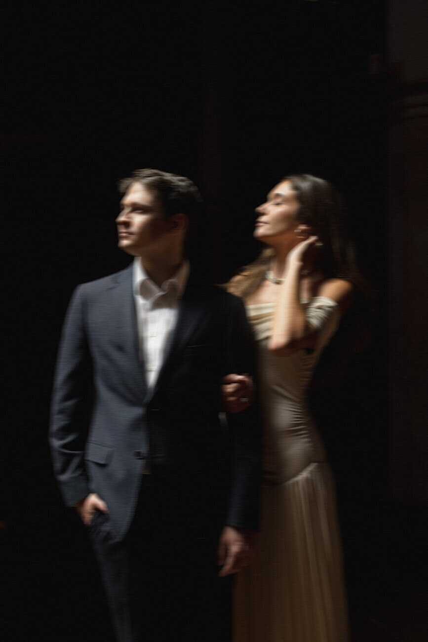 Blurry photo of couple looking towards moody lighting