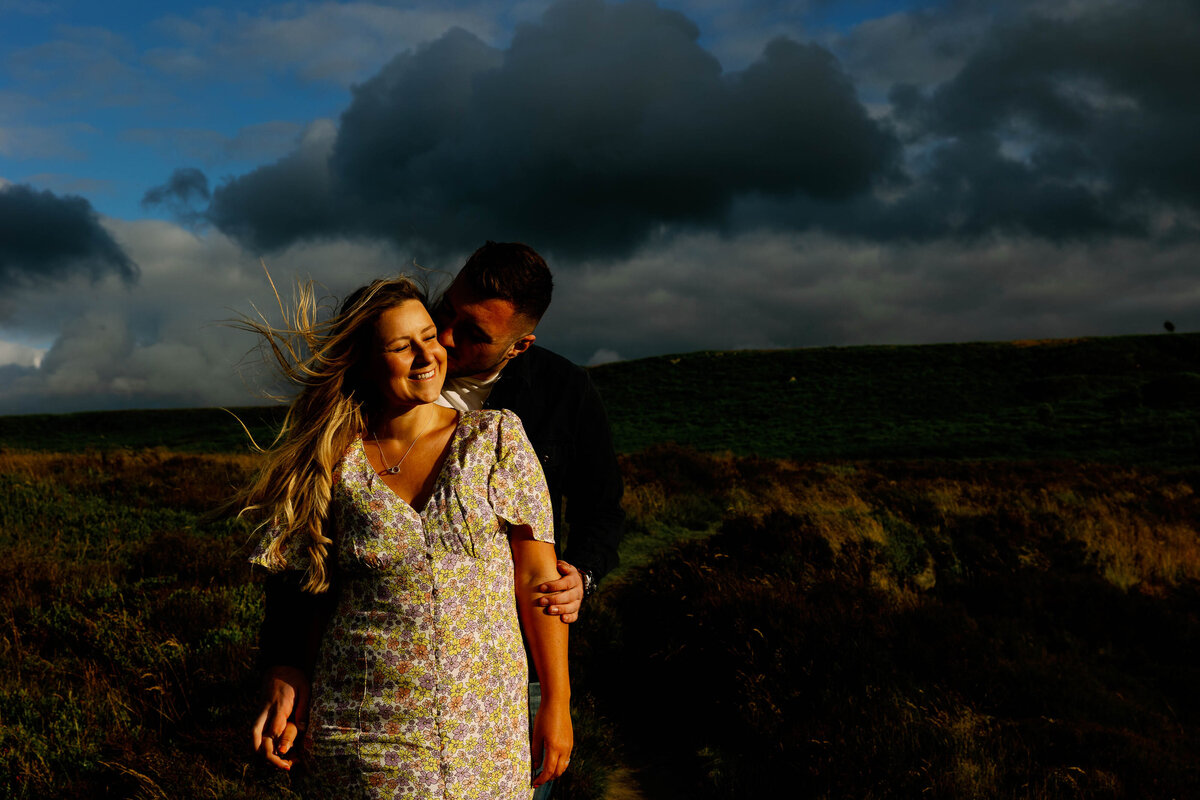 A wind swept and golden light lit couple on their pre wedding shoot on Ilkley Moor