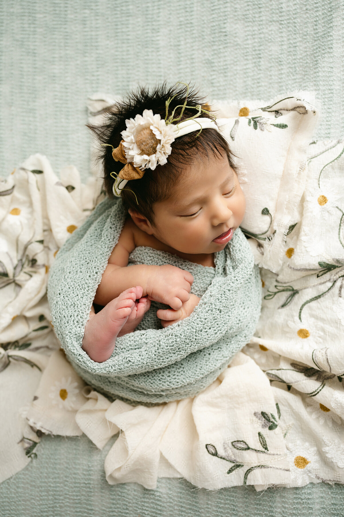 Our natural newborn photography captures your little one’s innocence and beauty. This sweet baby girl is wrapped in soft fabric, surrounded by delicate sunflowers. Perfect for your Pittsburgh baby photoshoot.