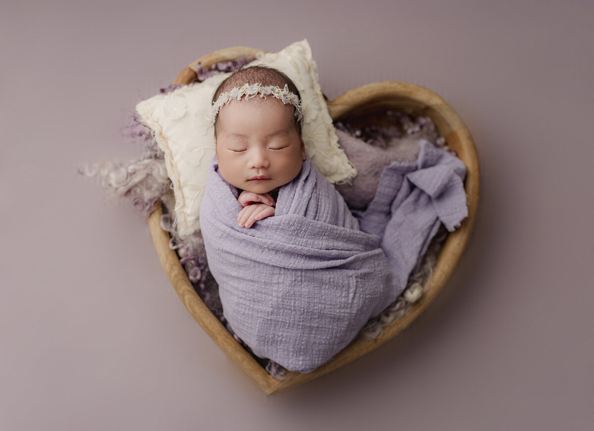 baby girl in purple heart basket