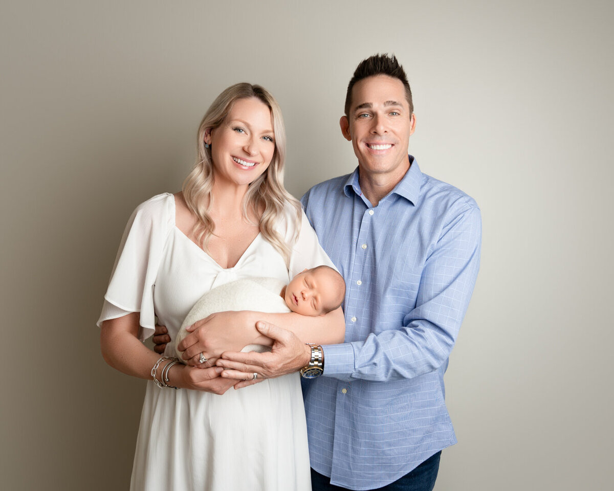 Mom and dad holding newborn during professional family photo session in Houston
