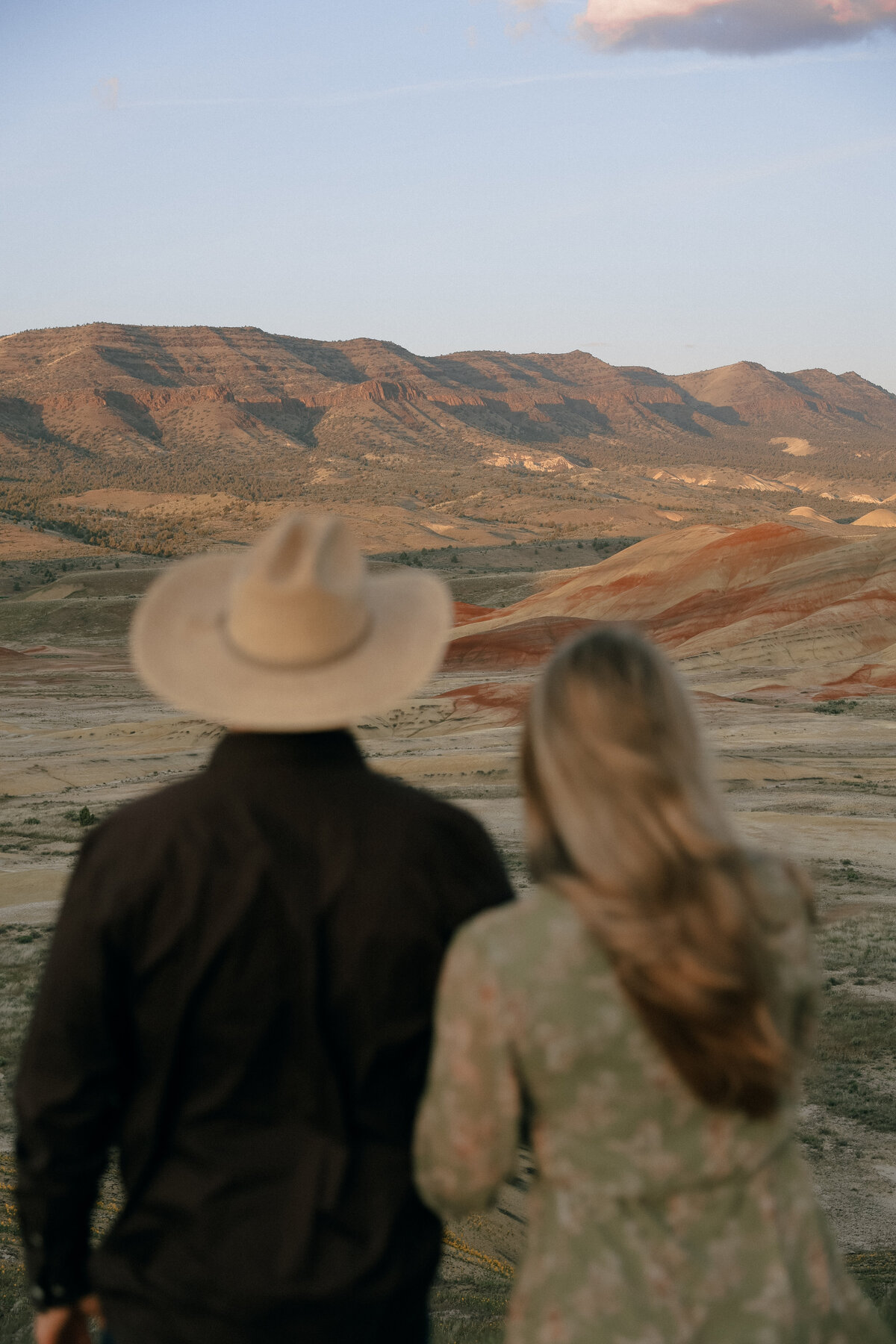 Western Couple Looking Out Over Painted Hills at Sunset