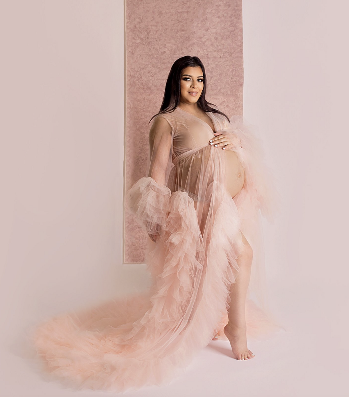 Pregnant women wearing pink gown during maternity photoshoot im Franklin Tennessee photography studio