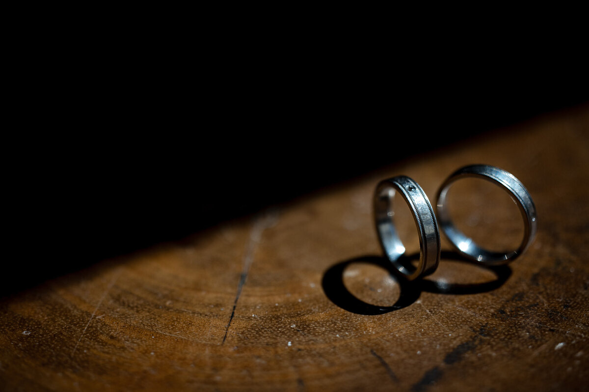 Two wedding bands sit on a wooden table at a destination wedding in Puerto Rico