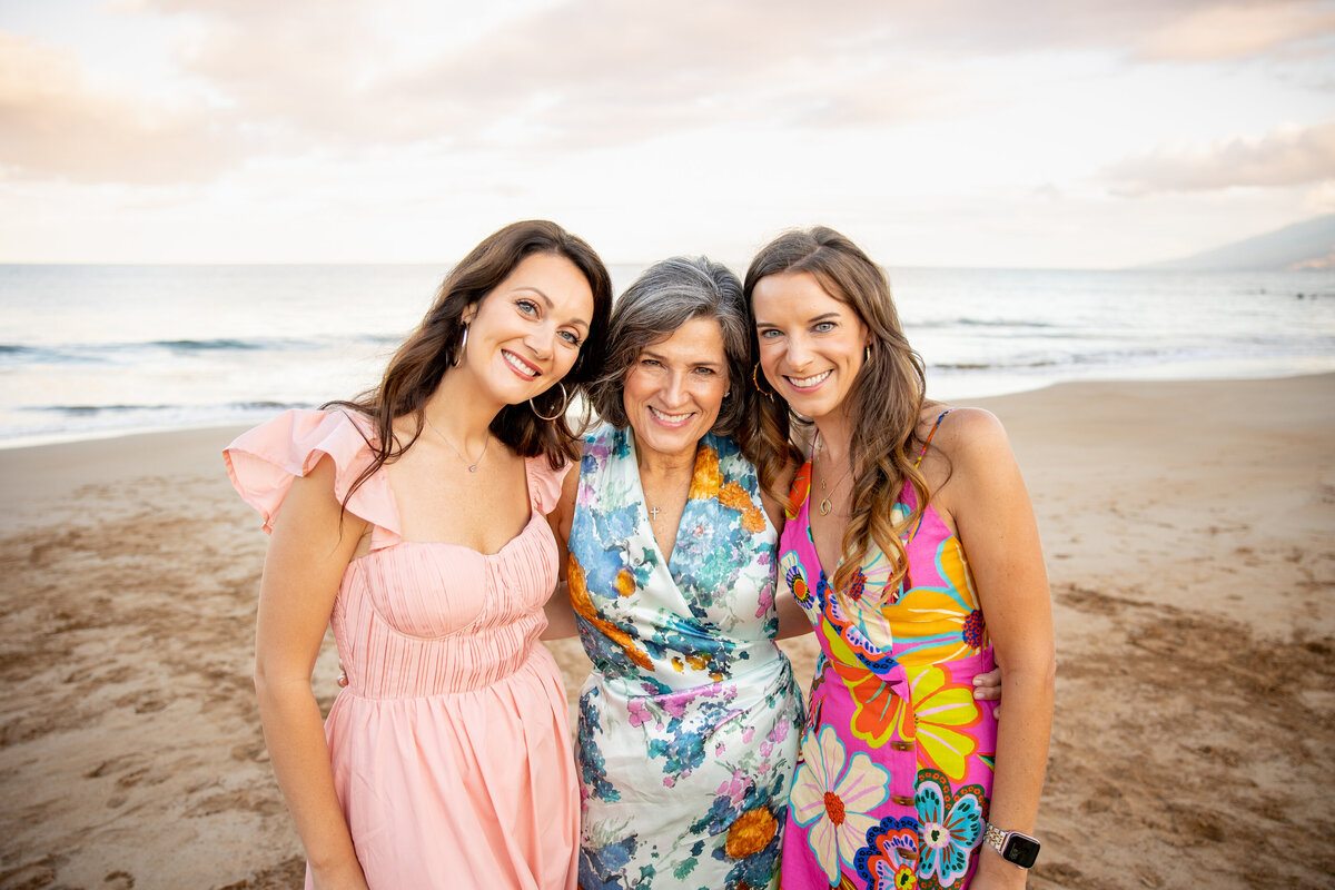 Maui Family Photographers capture mother hugging daughters on beach during family beach photos