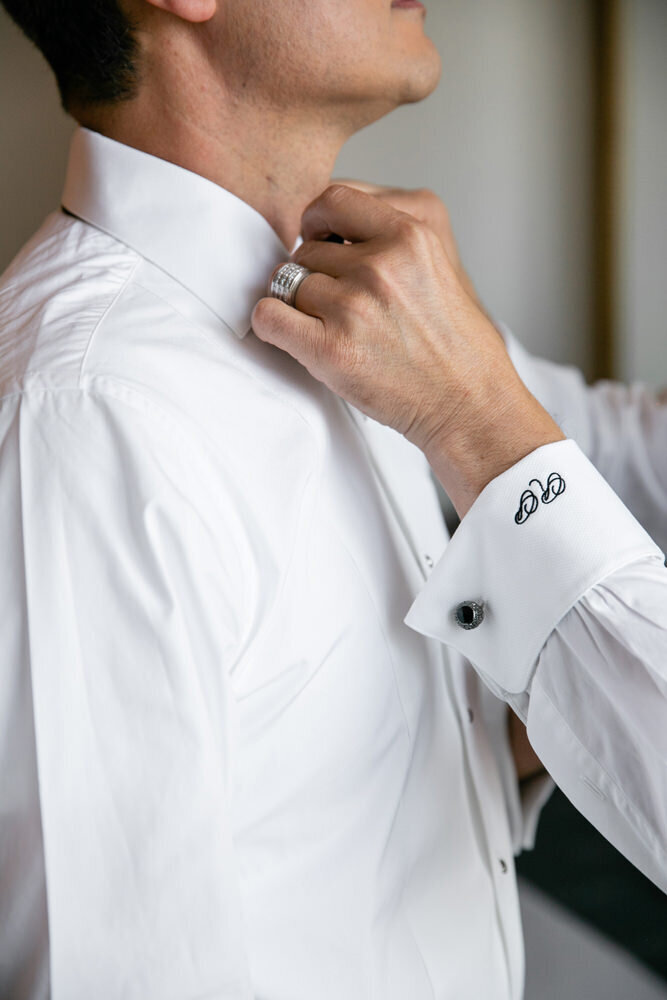 A person holding a man with his bow tie