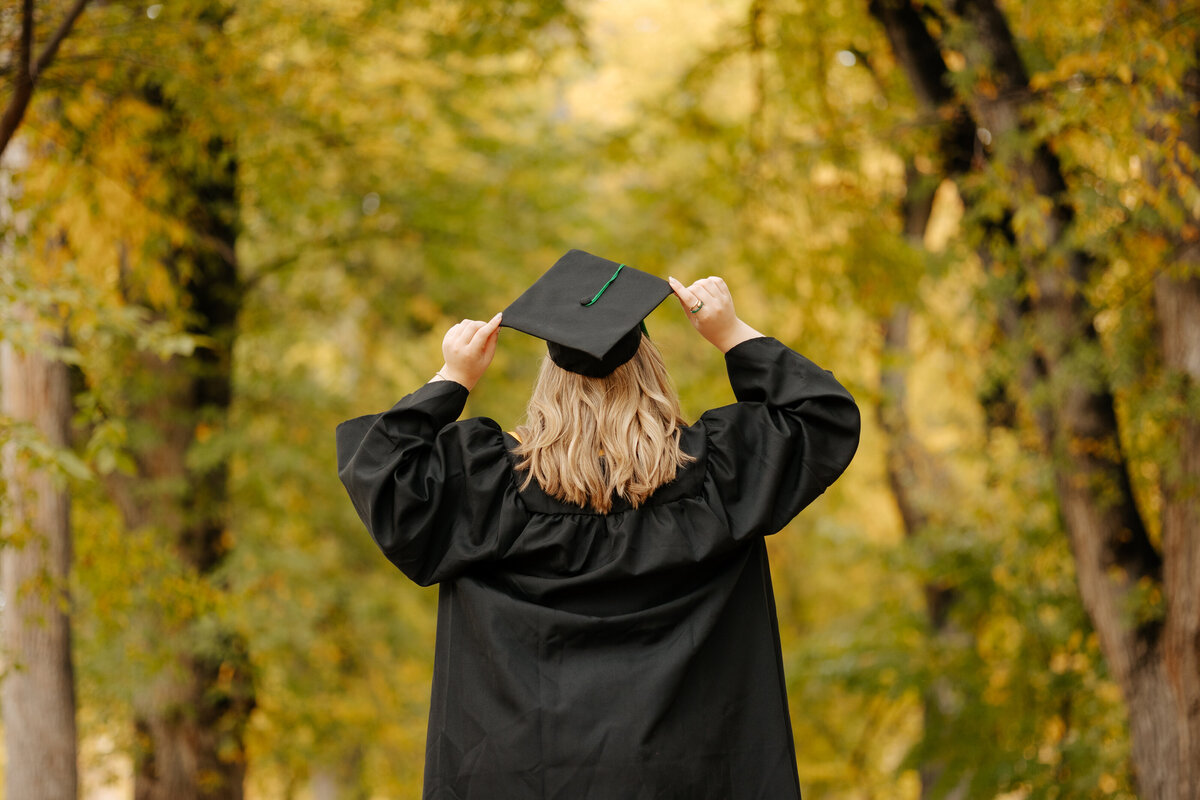 A Colorado State University graduate holds her cap in celebration during her fall grad session on The Oval in Fort Collins, Colorado.