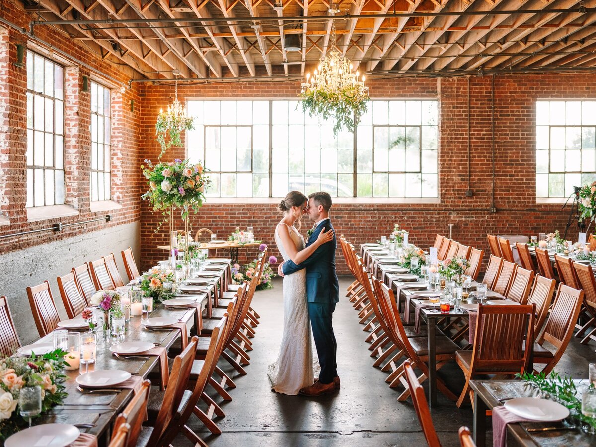 Bride and groom have a moment seeing their untouched reception setup at their wedding at Moss Denver.