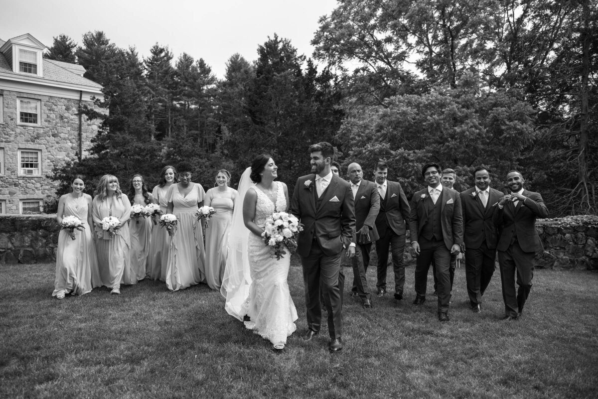 bride and groom walking with their wedding party along the lawn at the connors center