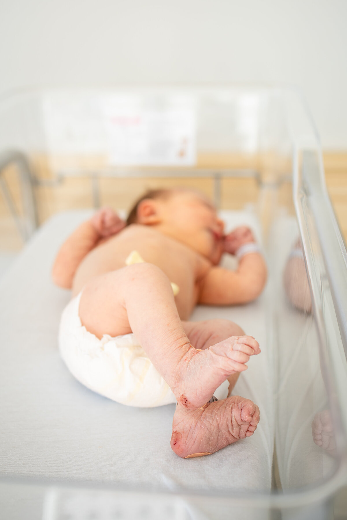 Raw, authentic photo of newborn baby in basinnet